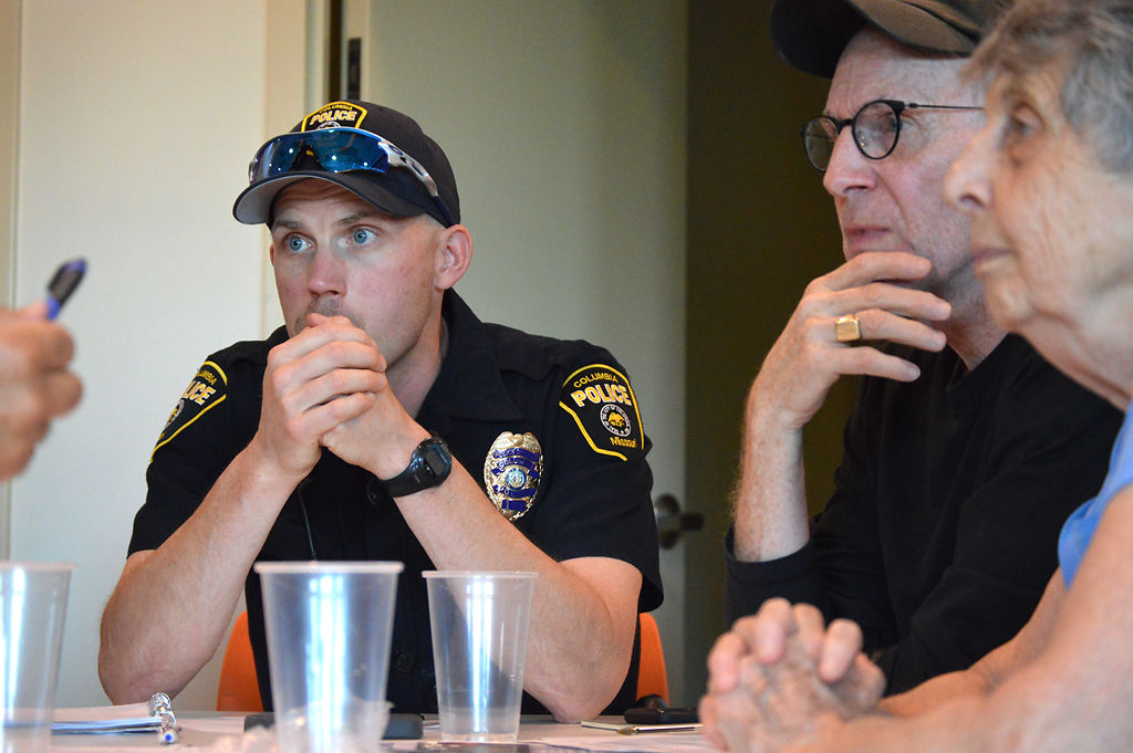 Officer Justin Anthony sits with Columbia residents Dale Wilcox and Margaret Tyler